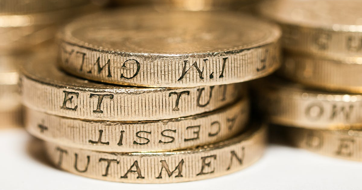 A close-up photo of stacked British pound coins.